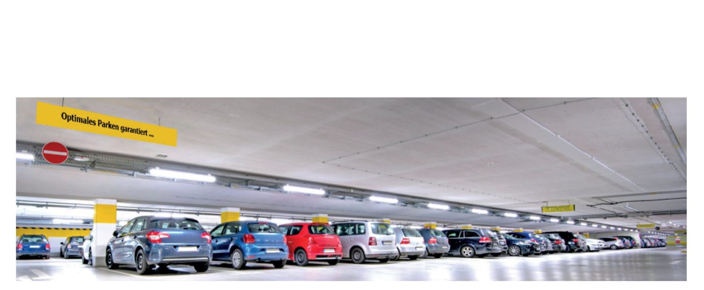 Blick durch eine helle Tiefgarage mit besetzten Stellplätzen