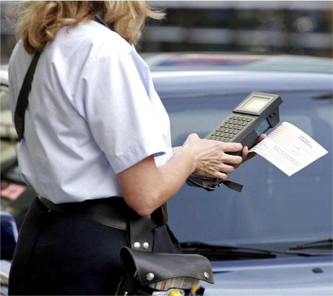 Mitarbeiterin erfasst ein falsch abgestelltes Fahrzeug mit einem Handgerät